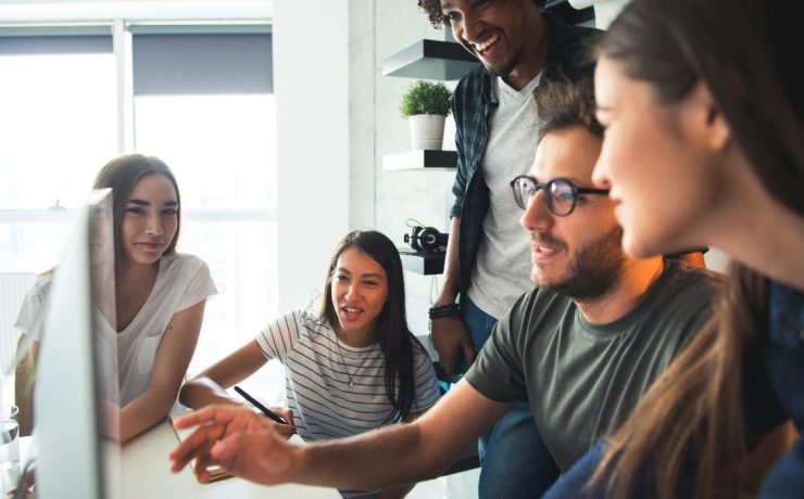 startup employees looking at a computer screen