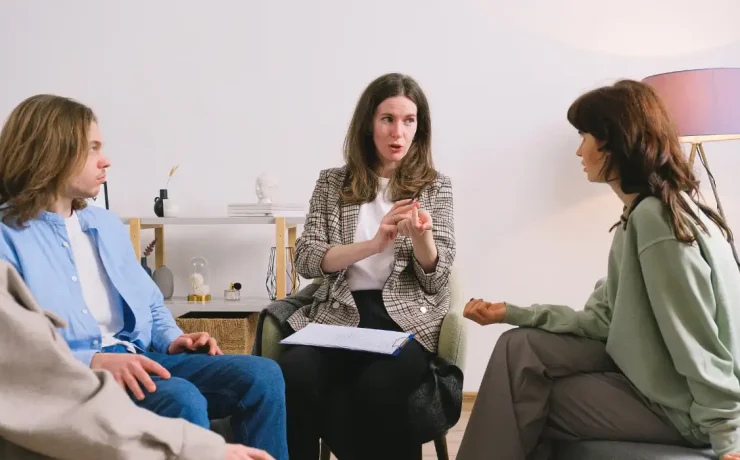A group of executives listening to a person speaking to them.