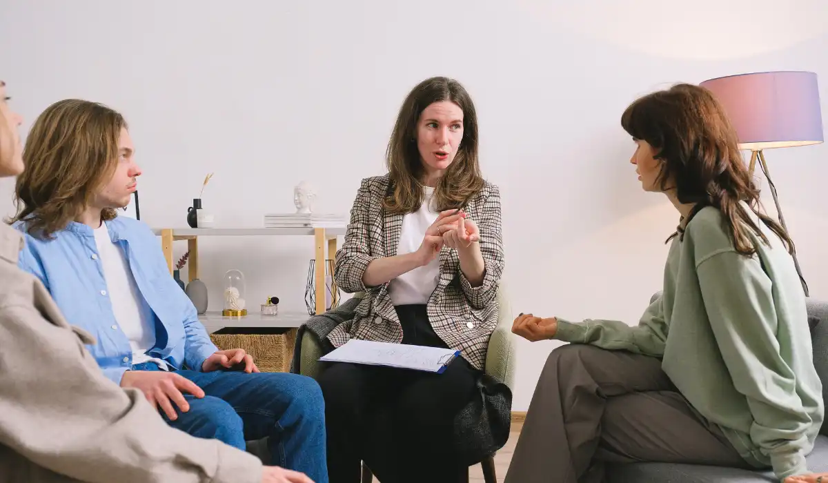 A group of executives listening to a person speaking to them.