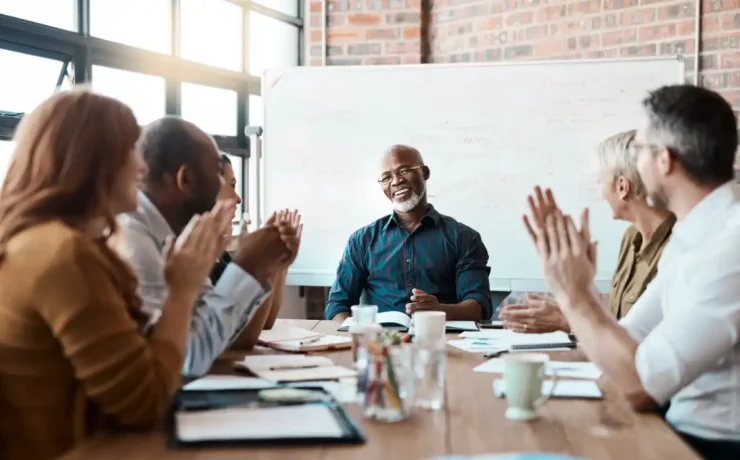 executives clapping while looking at a person