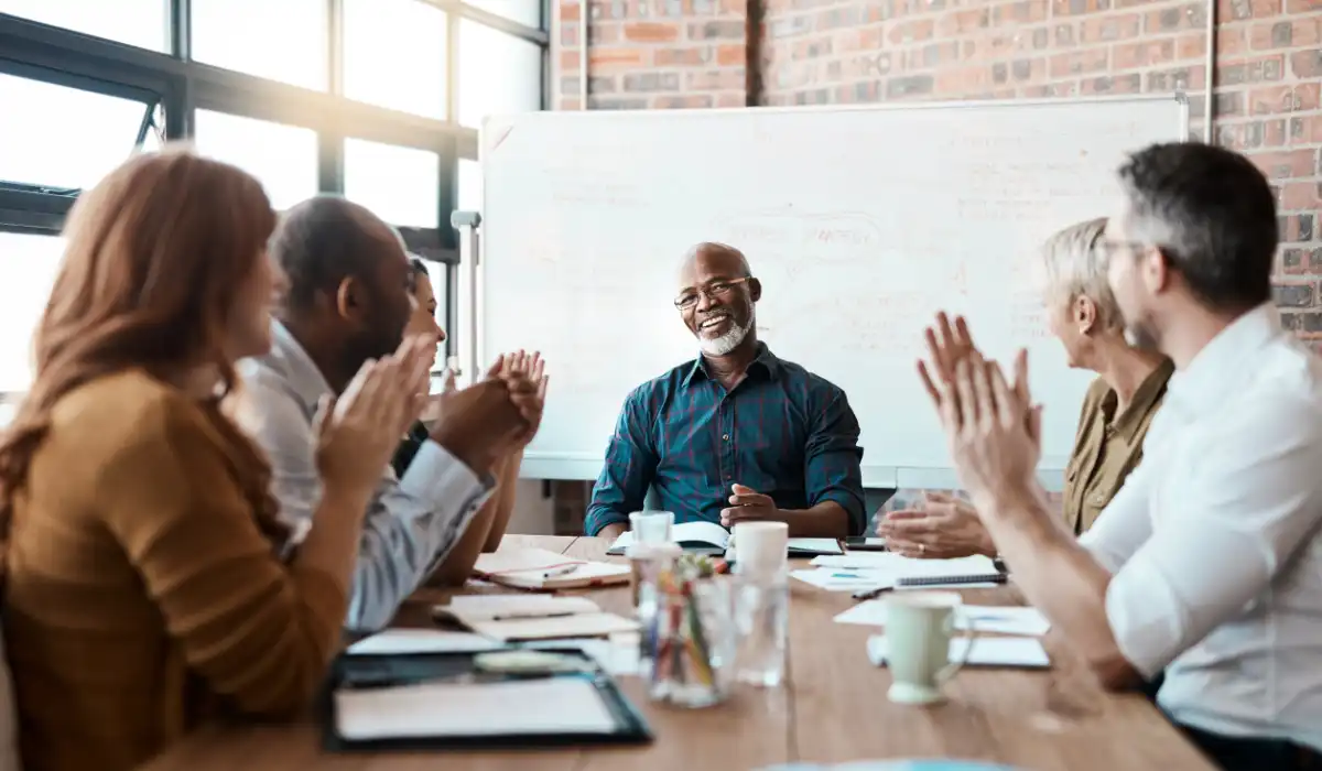 executives clapping while looking at a person