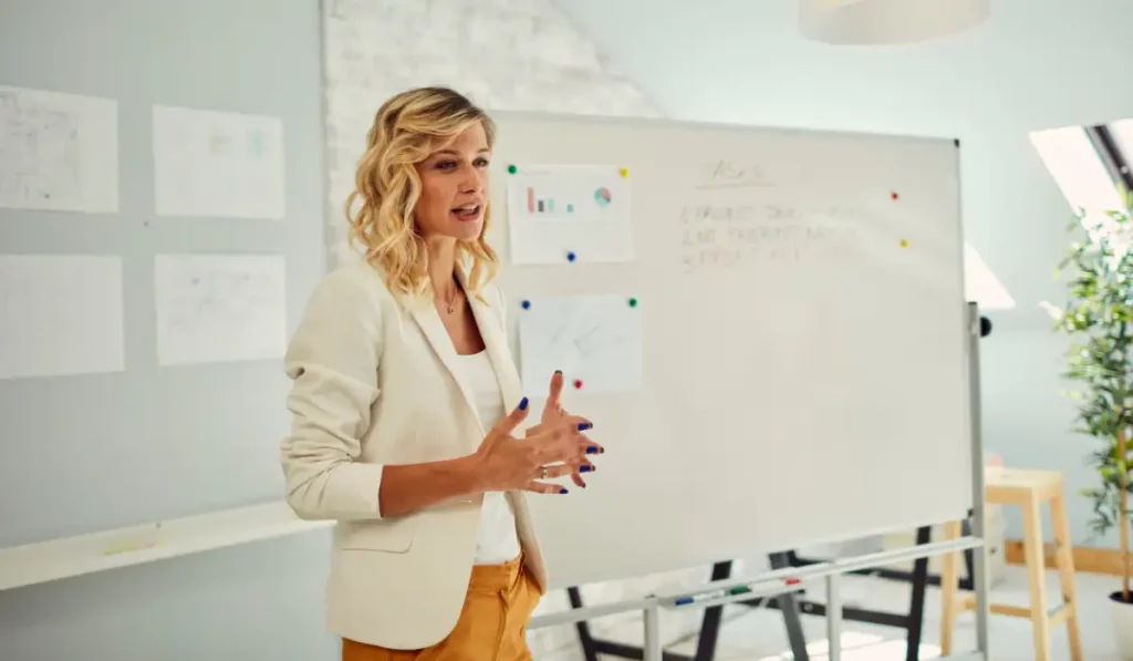 a person giving a presentation in front of a white board in an office