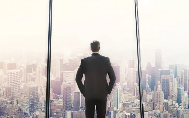 CEO faces a large window overlooking tall city buildings