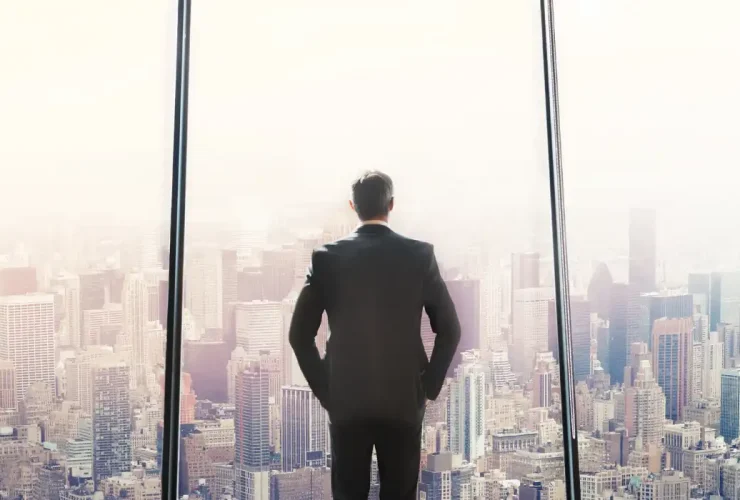 CEO faces a large window overlooking tall city buildings