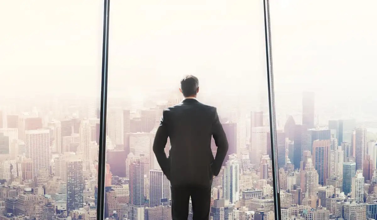 CEO faces a large window overlooking tall city buildings