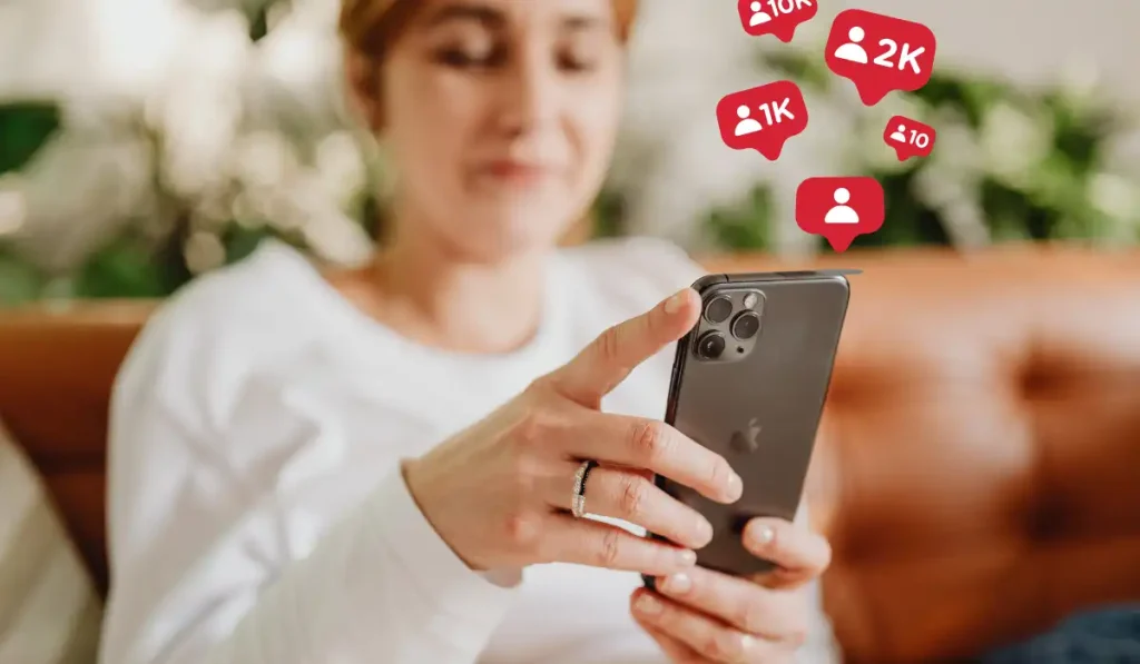 Phone user with illustrated social media followers appearing above the device
