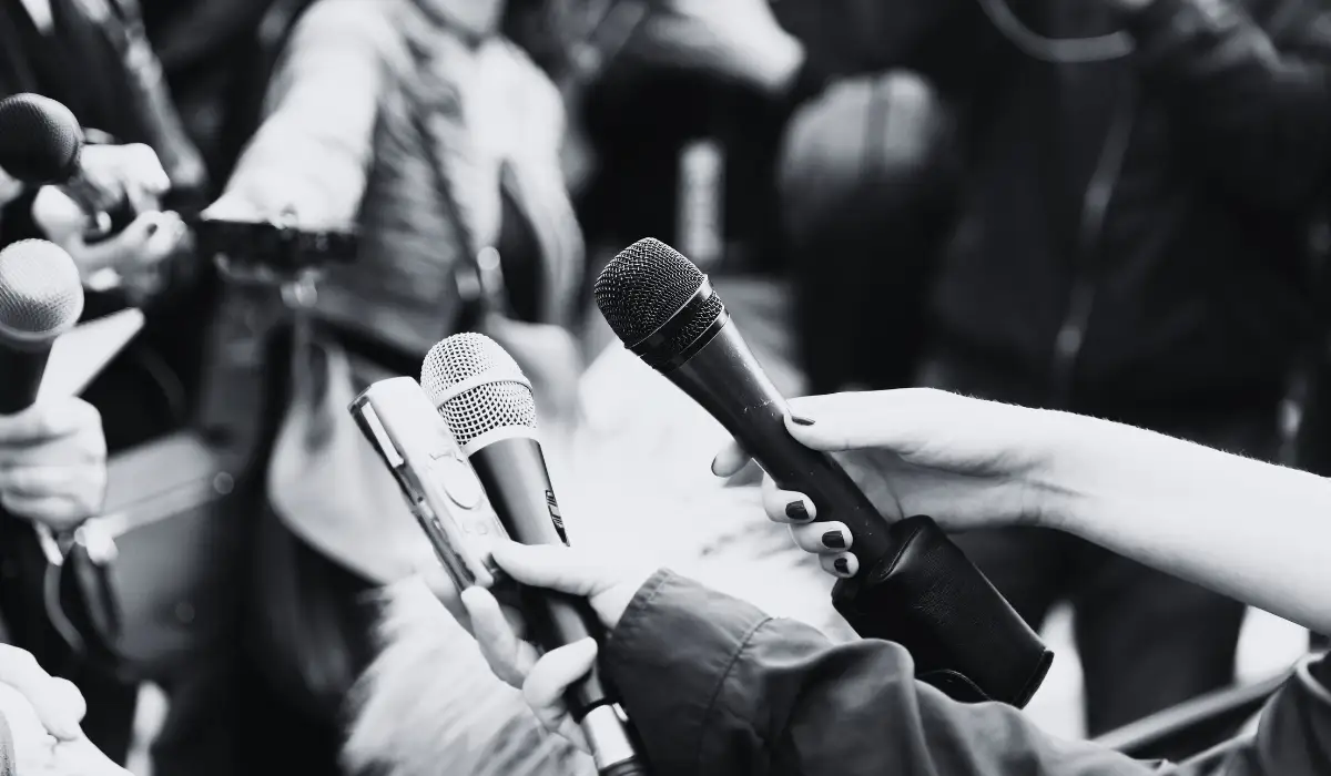 Multiple journalists holding mics.
